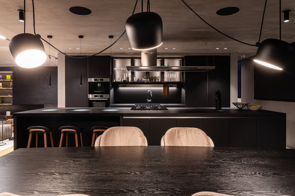 Explore a modern, stylish kitchen interior in Bogotá, featuring sleek black design and contemporary lighting.